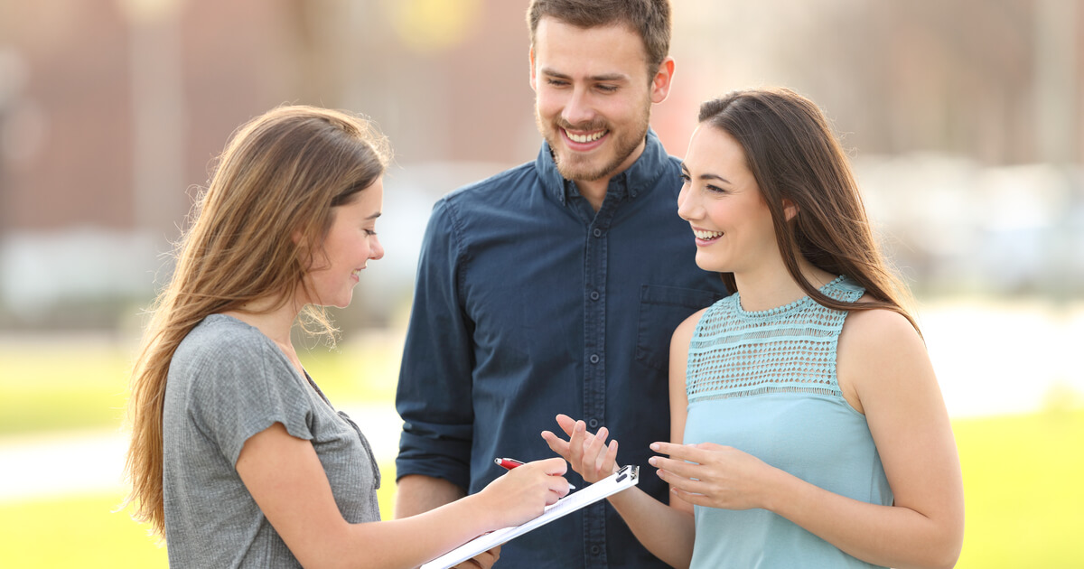 Studenten führen eine Umfrage durch, junge Dame antwortet auf die Fragen